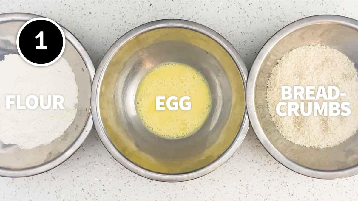 A breading station, three bowls containing flour, egg and then panko breadcrumbs.