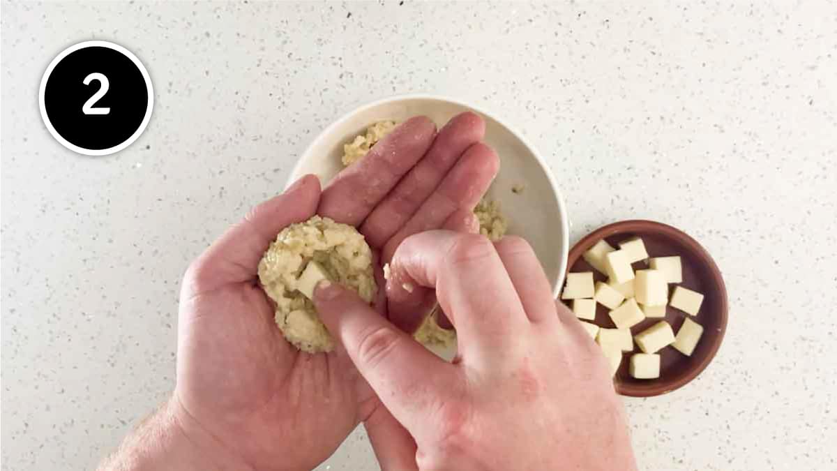 Rolling and stuffing cold risotto into balls for Italian rice balls, supplì