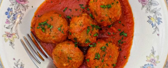 A plate of Pallotte - Cacio e Uova (Bread & Cheese balls) in a tomato sauce.