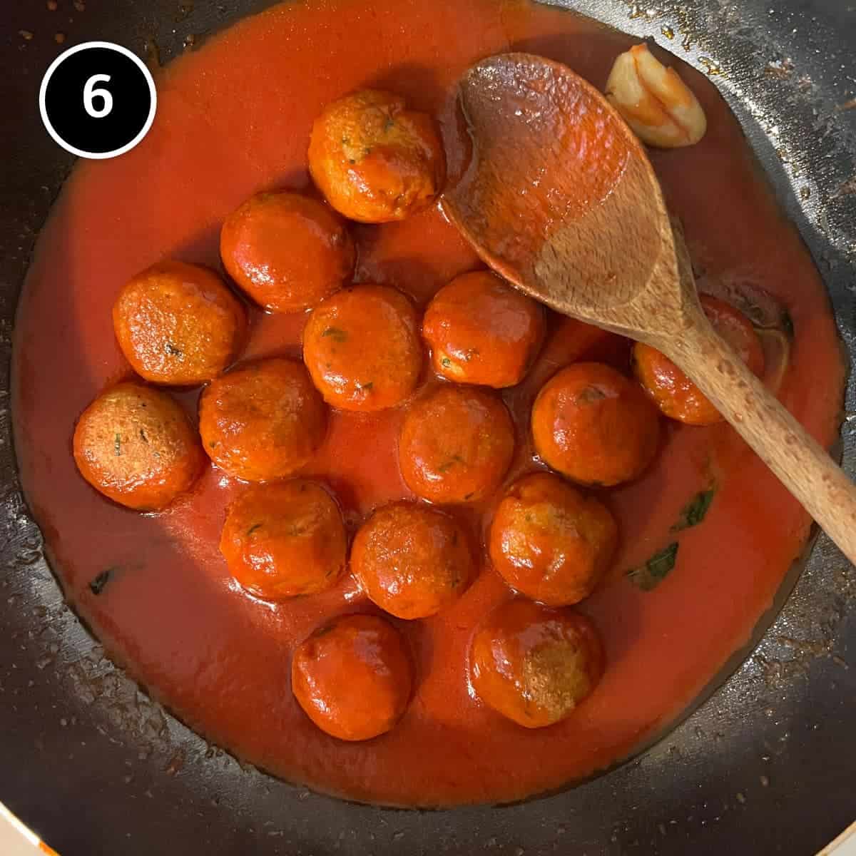 Simmering the bread balls in tomato sauce for Pallotte Cacio e Uova (Cheese & Bread Balls)