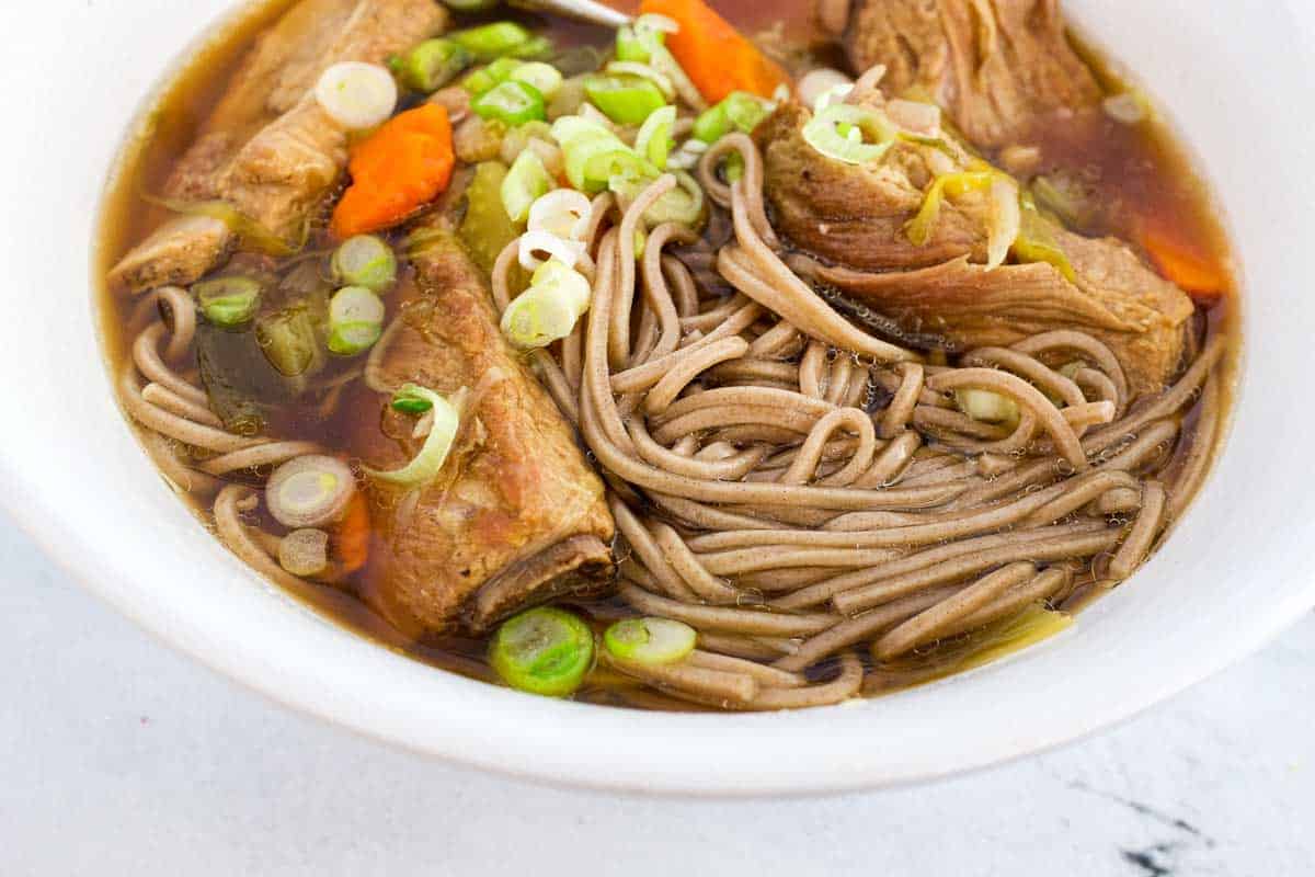 A bowl of pork rib soup with soba noodles