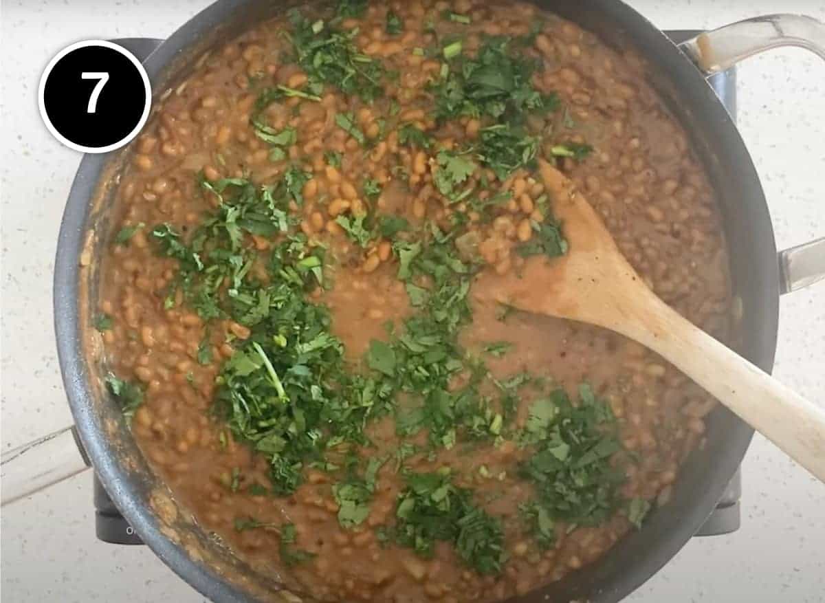 Sprinkling a Red Moong Dal Curry with fresh cilantro