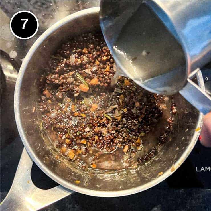 Adding a little of the cooking liquid to the cooked lentils for Salt Pork with Puy Lentils (Petit Sale aux Lentilles)