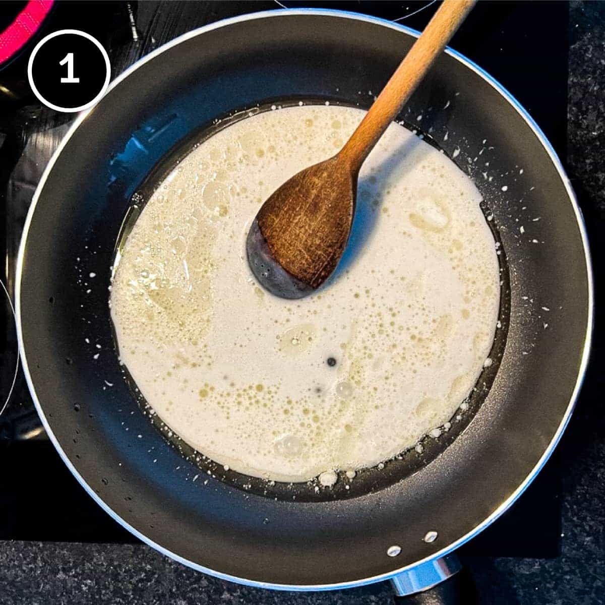 Simmering the coconut milk for a satay chicken curry