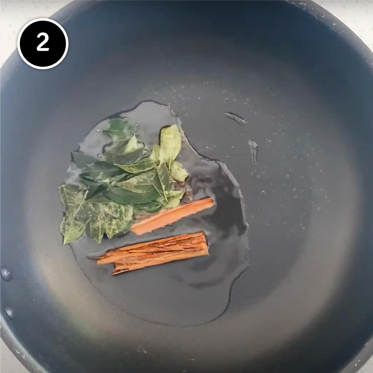 Frying curry leaves, cinnamon and cloves for Goan Chicken Vindaloo