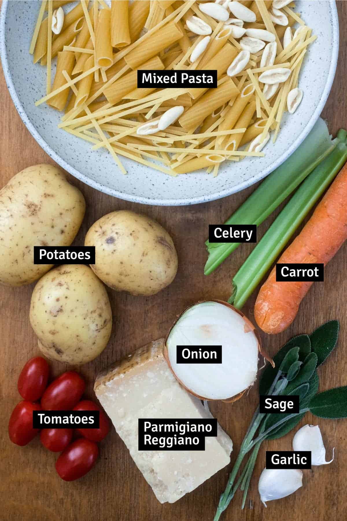 All the ingredients for Pasta with Potatoes (Pasta e Patate) on a wooden surface.