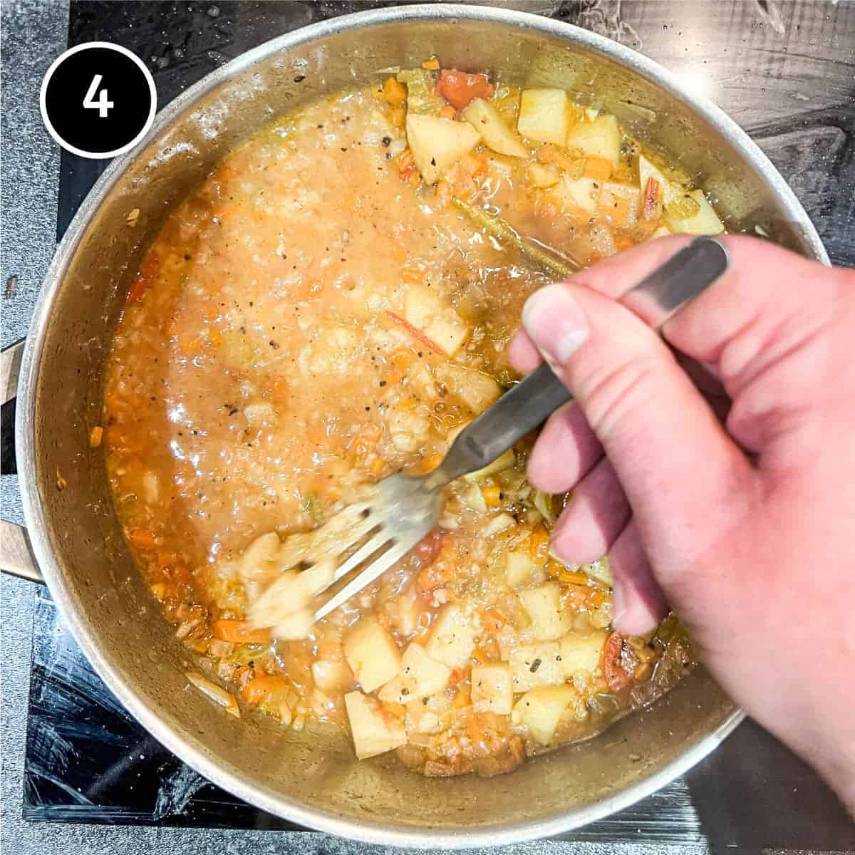 Mashing the cooked potatoes into the sauce for Pasta with Potatoes (Pasta e Patate)