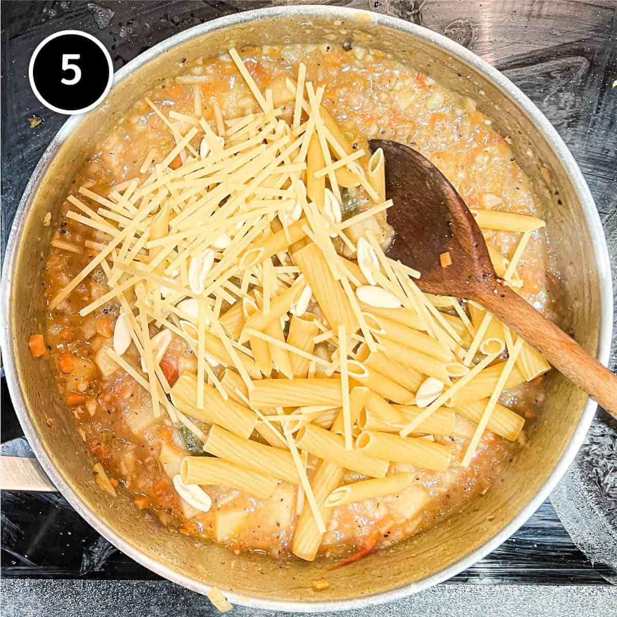 Adding the mixed dry pasta into the Pasta with Potatoes (Pasta e Patate)