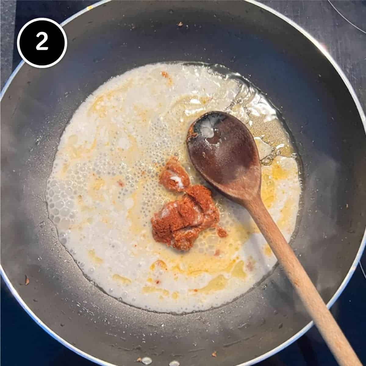 Frying the red curry paste with a little oil and coconut milk for Thai Curry Noodle Soup with Salmon