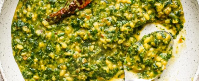 A bowl of Spinach Dal (Dal Palak) with a whole Kashmiri chilli in it.