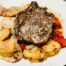 A lamb chop with potatoes on a plate