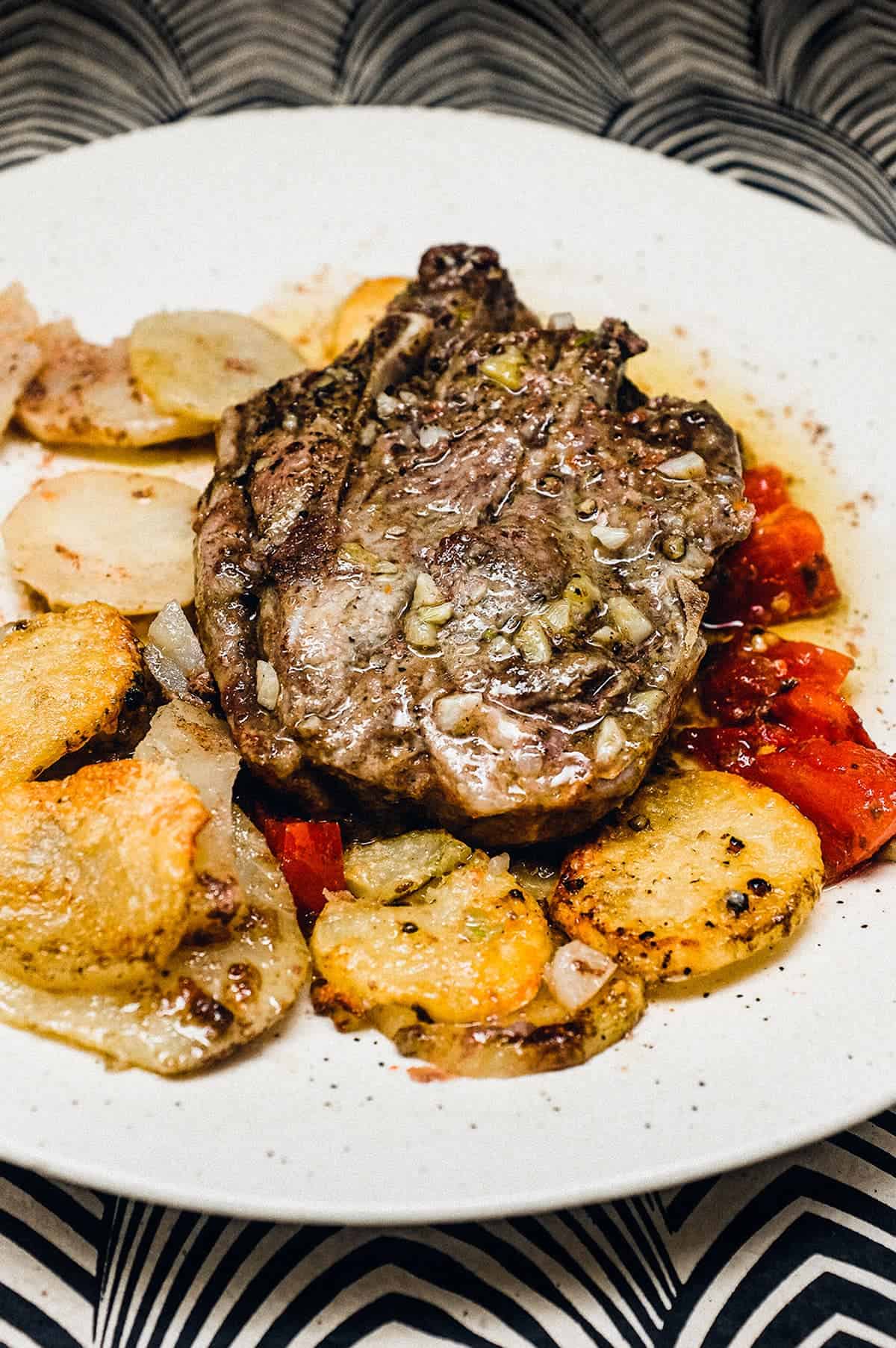 A lamb chop with potatoes on a plate