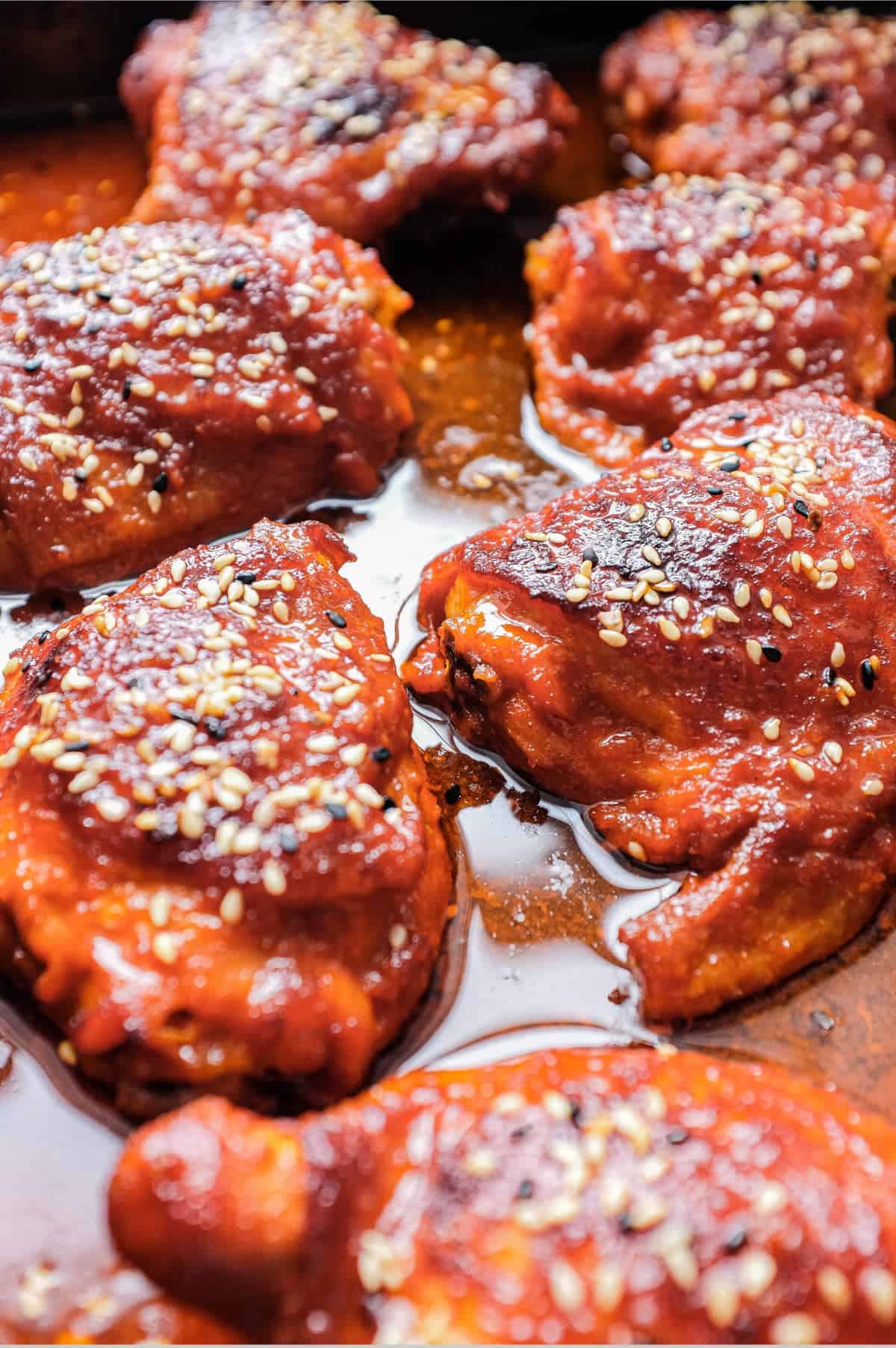 A plate of Korean Gochujang Chicken and chopsticks with salad on the side.