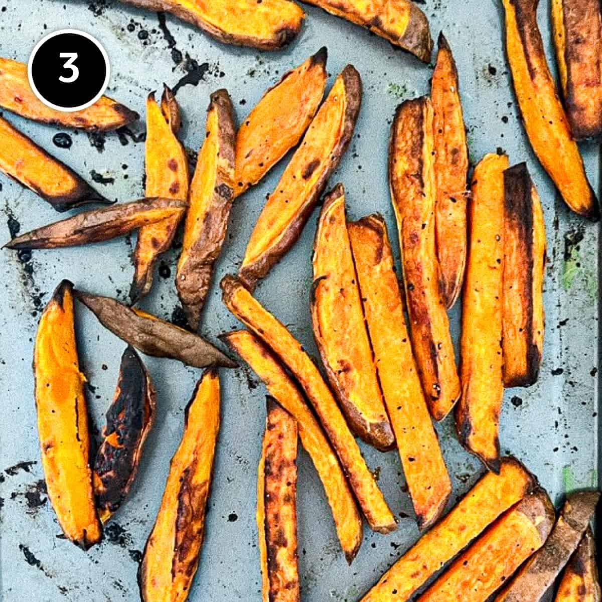 Roasted and charred sweet potato fries on a sheet pan