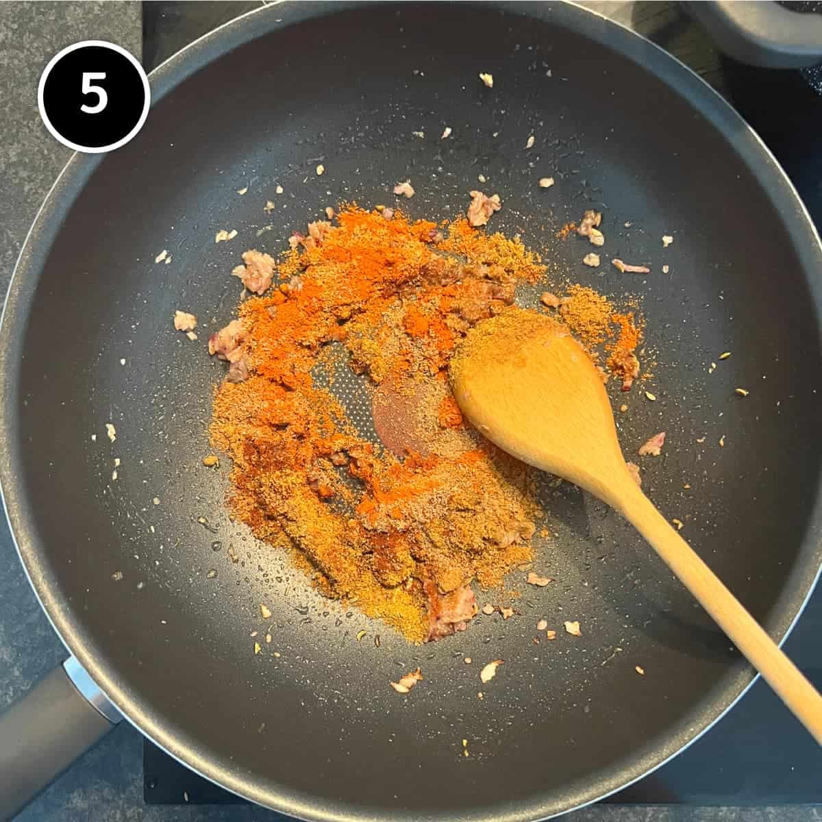 Adding dried spices to a fried onion paste