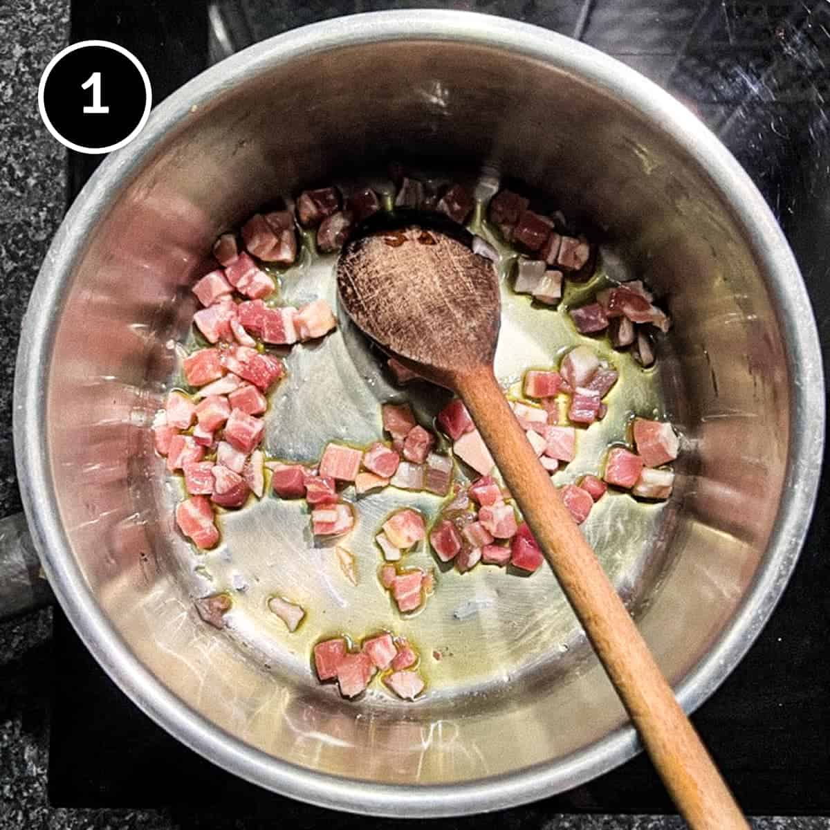 Frying pancetta bacon in a small pan with a wooden spoon