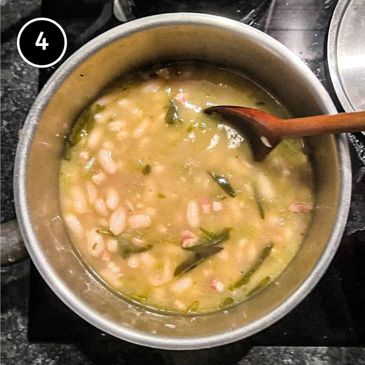 Cooked Italian Cannellini beans in a pan with a spoon