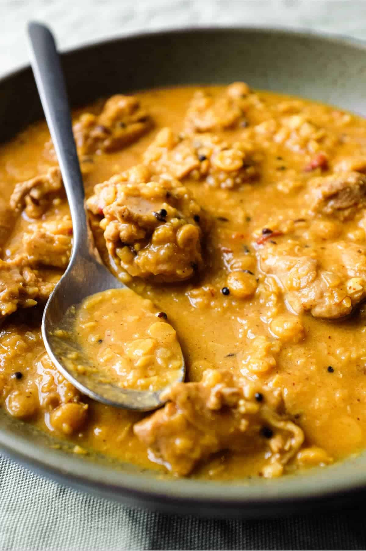 A bowl of lentil curry with a spoon