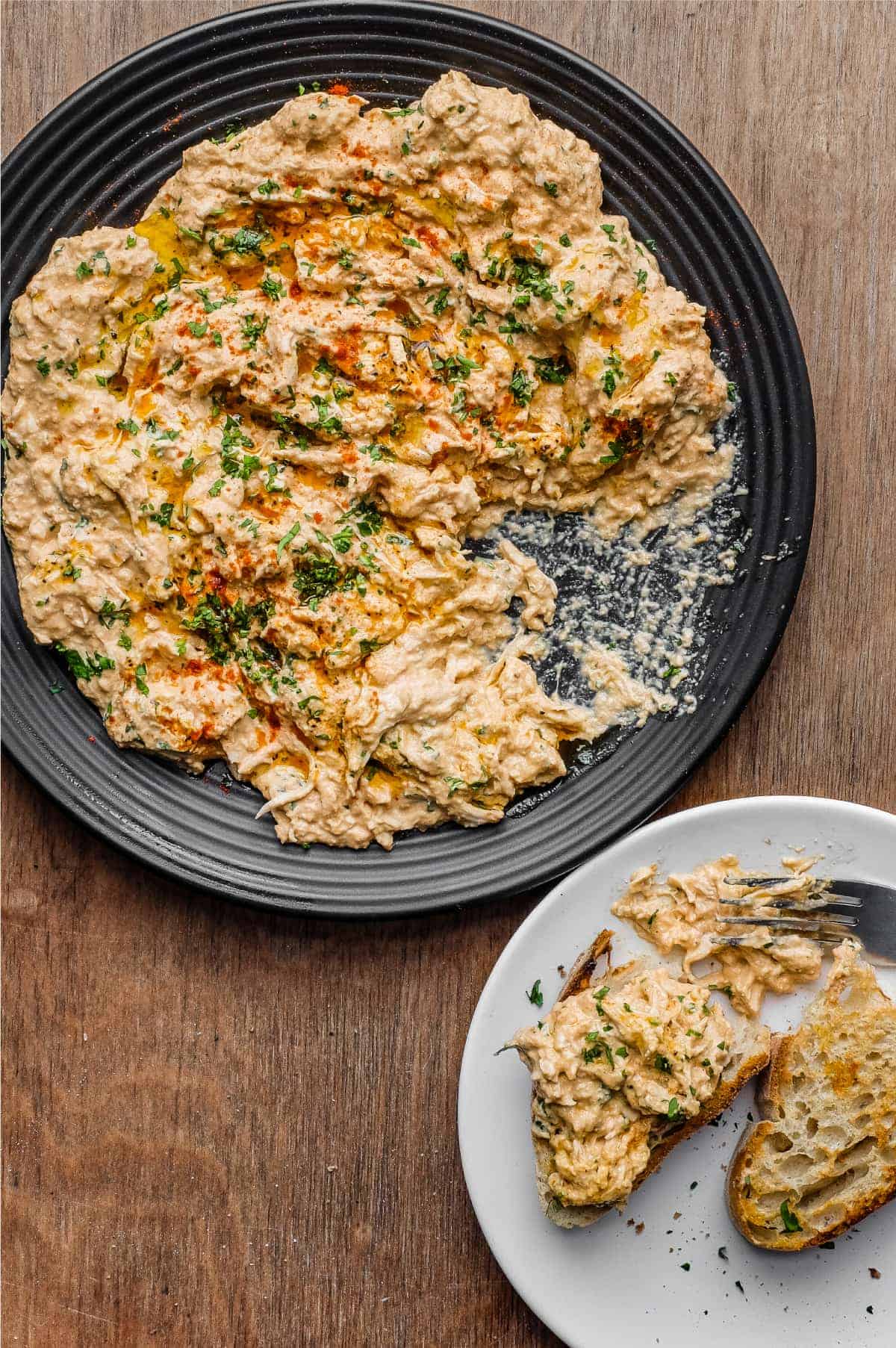 A plate of Turkish Circassian Chicken alongside two slices of crusty bread topped with the chicken