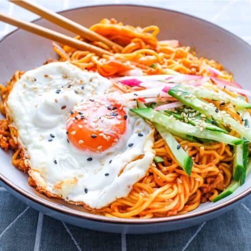 A bowl of Korean Gochujang Noodles with Pork with a fried egg on top