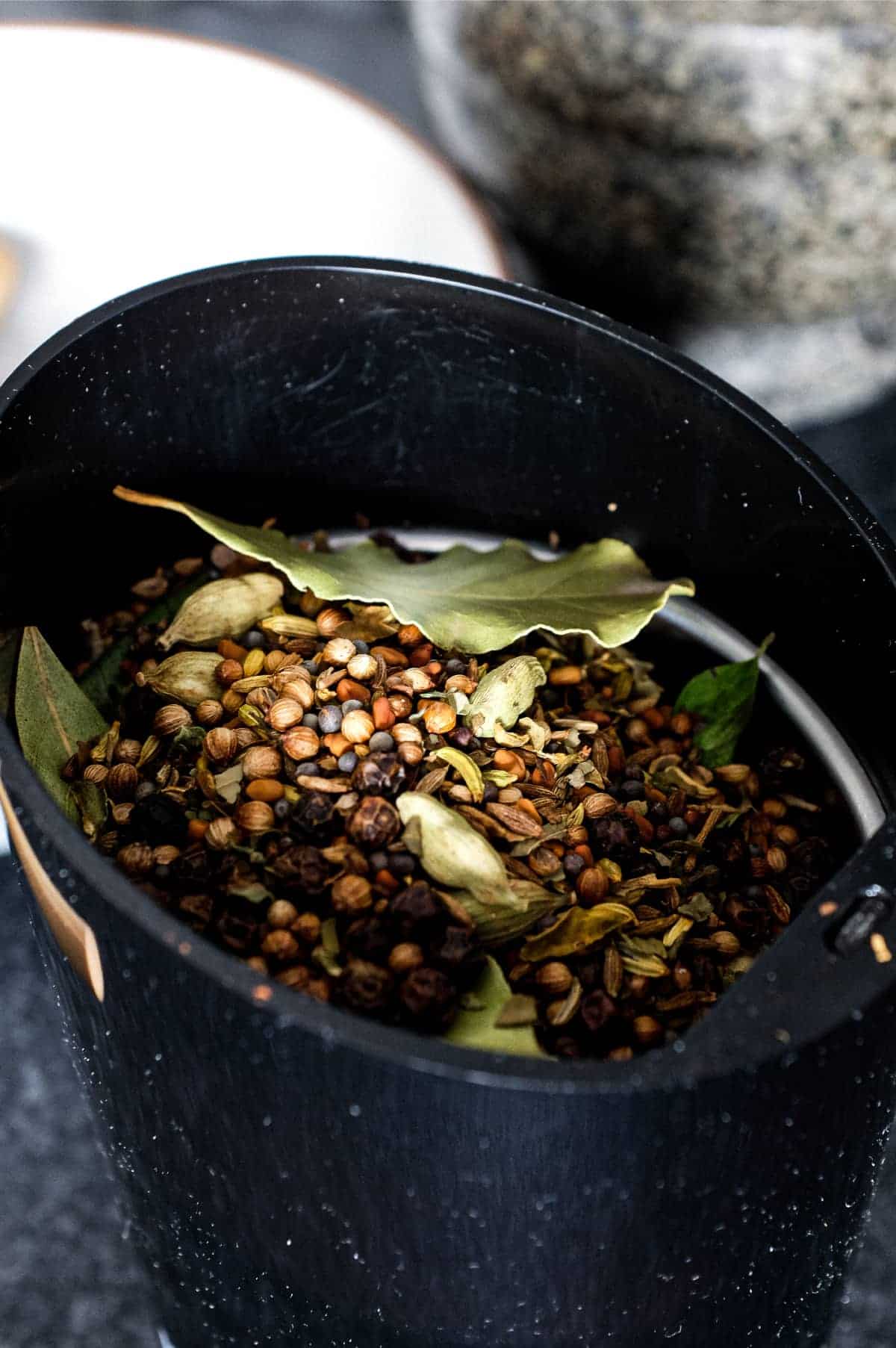 A spice grinder holding whole spices