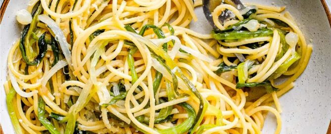 A bowl of spaghetti and wild onions with a fork