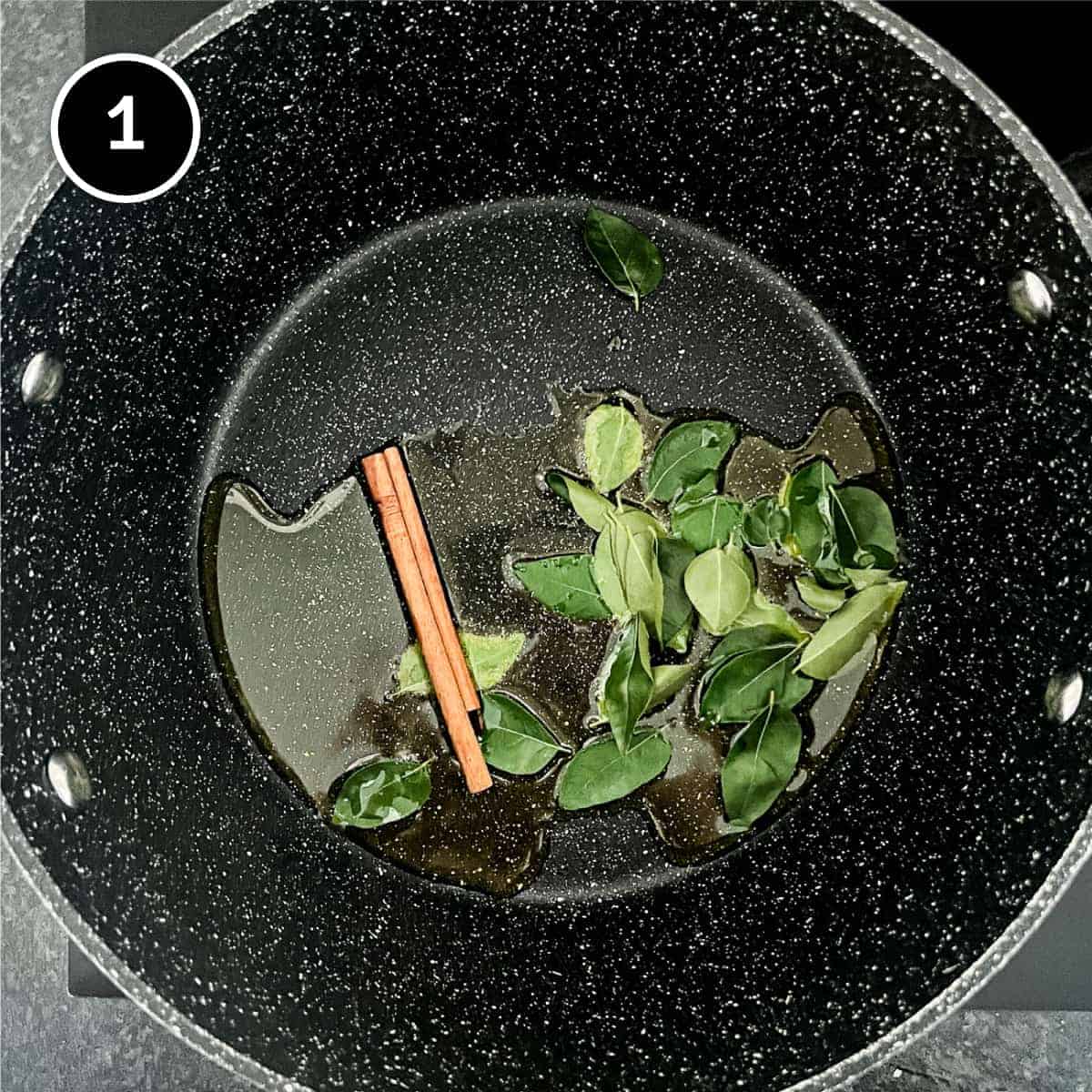 fresh curry leaves and a cinnamon stick frying in a pan