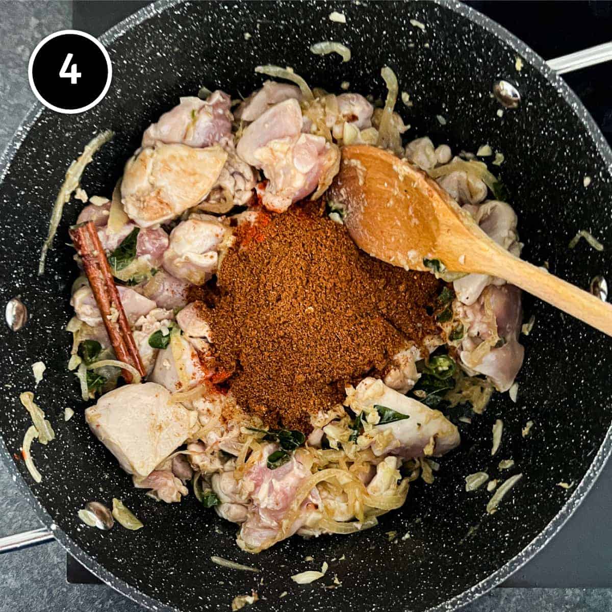 A curry powder being added to fried onions for a curry
