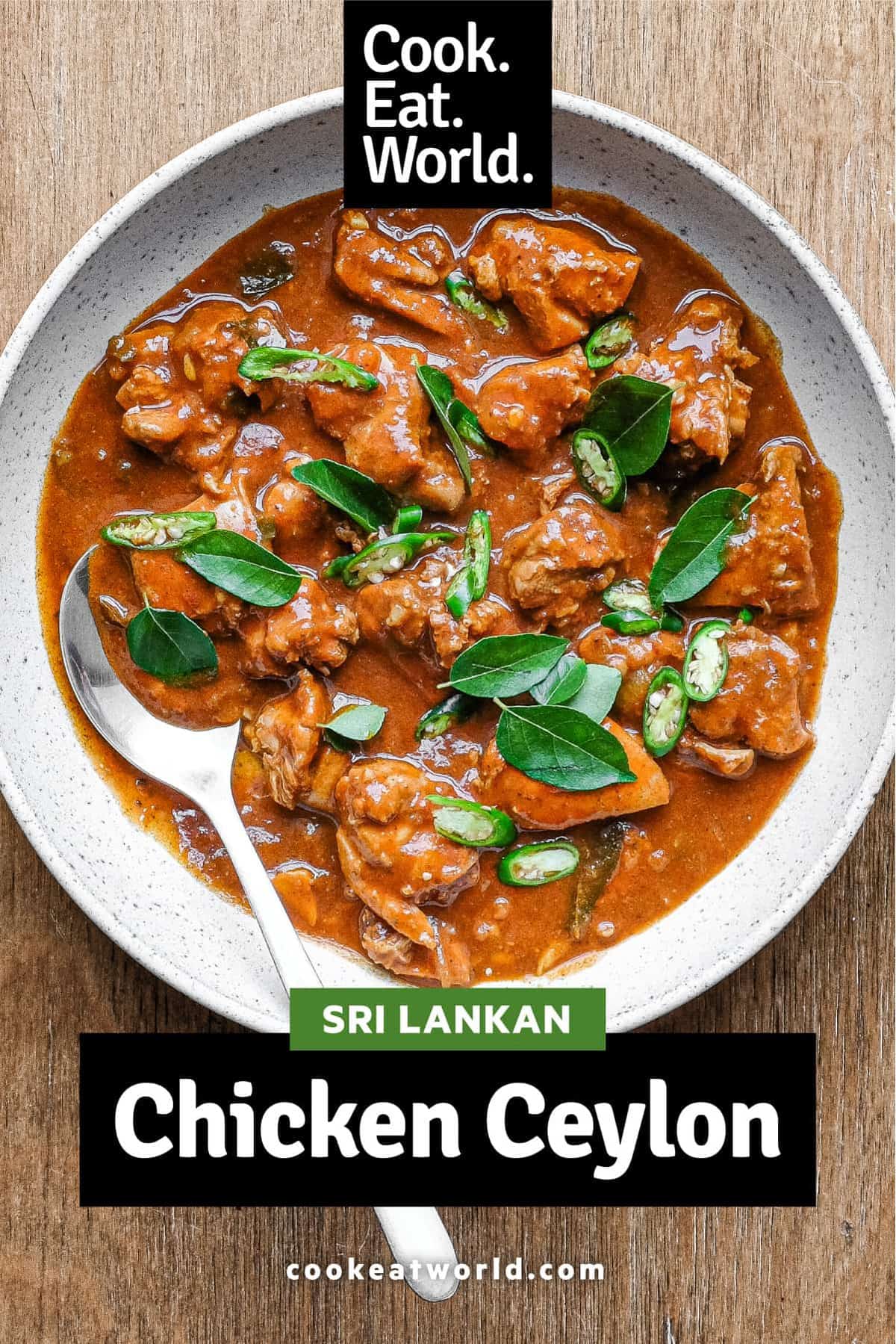 A bowl of Chicken Ceylon Curry scattered with fresh curry leaves