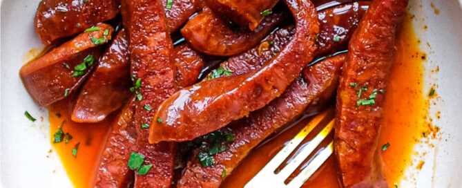 A small tapas bowl of Chorizo in a fino sherry sauce with a small tapas fork