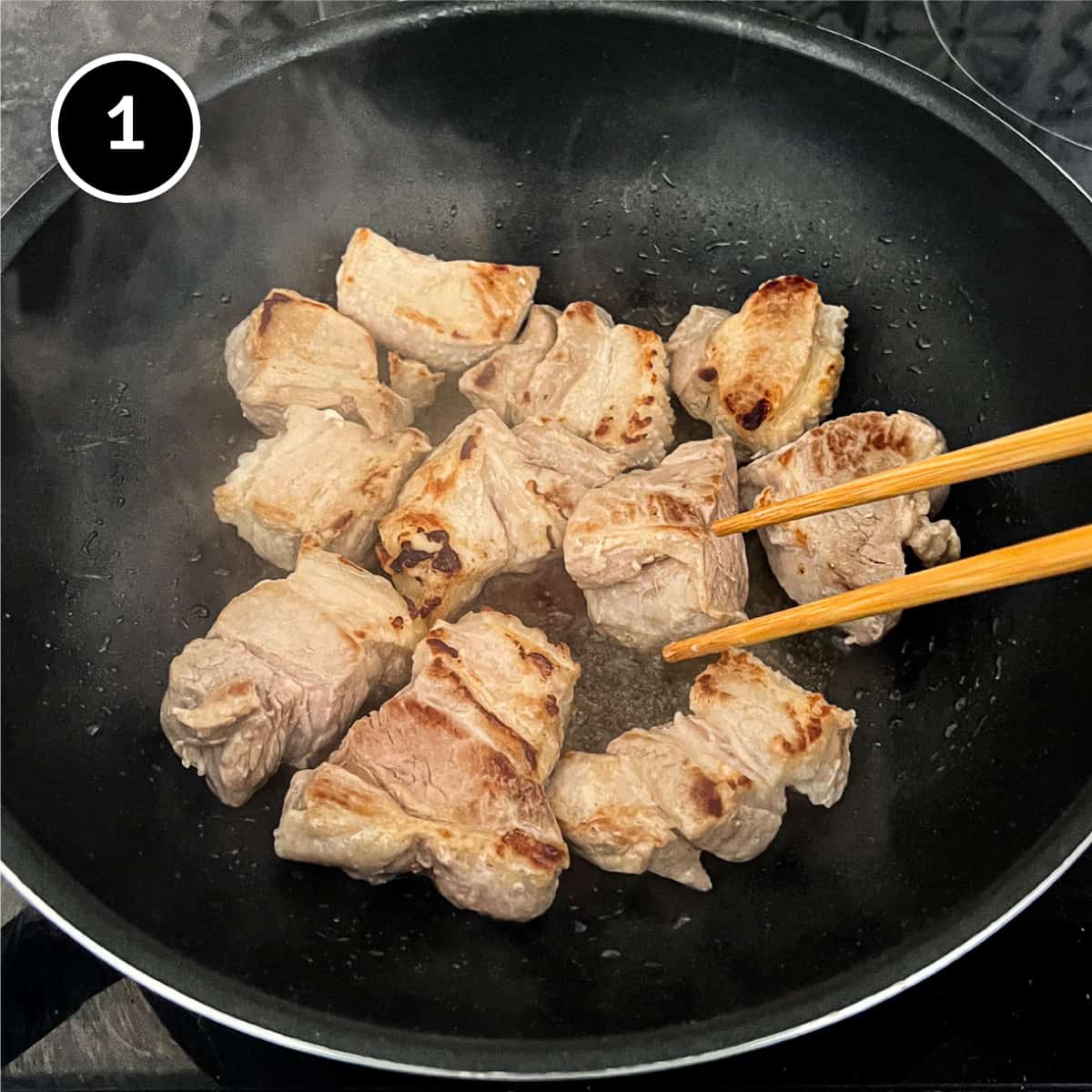 searing pork belly pieces in a pan