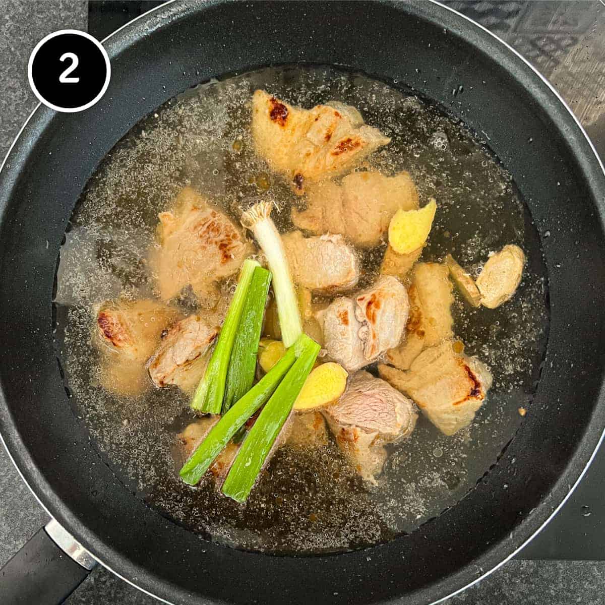 pork cooing in dashi broth with spring onion and ginger