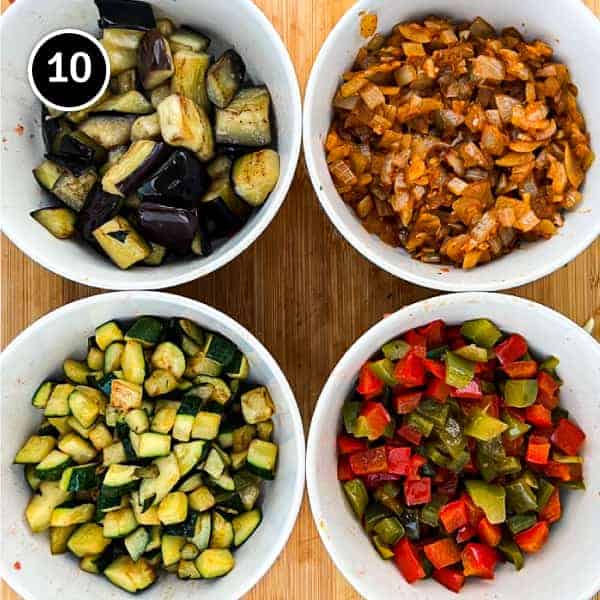 Four bowls holding diced and sautéed vegetables; eggplant, onion, zucchini and bell peppers for Spanish Pisto Manchego