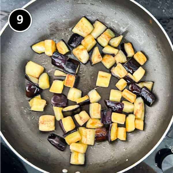 Diced eggplant frying in a pan