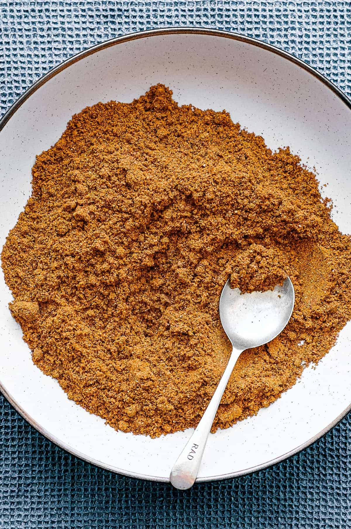 A bowl of Sri Lankan curry powder with a small spoon