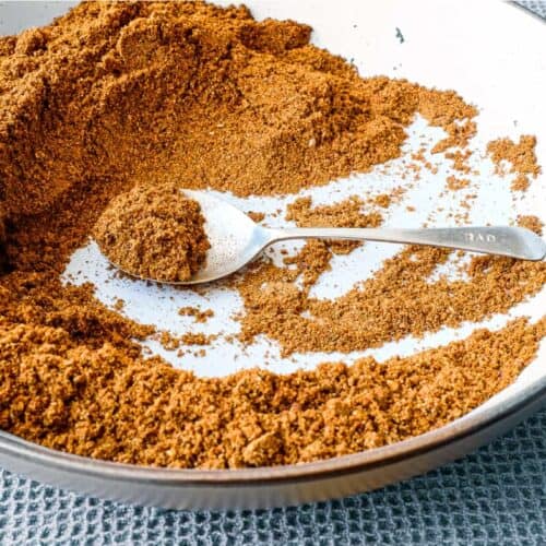 A small bowl of Sri Lankan curry powder with a spoon