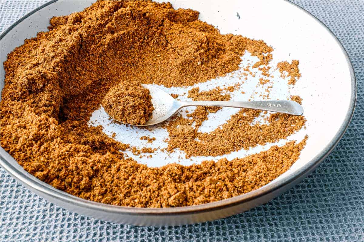 A small bowl of Sri Lankan curry powder with a spoon