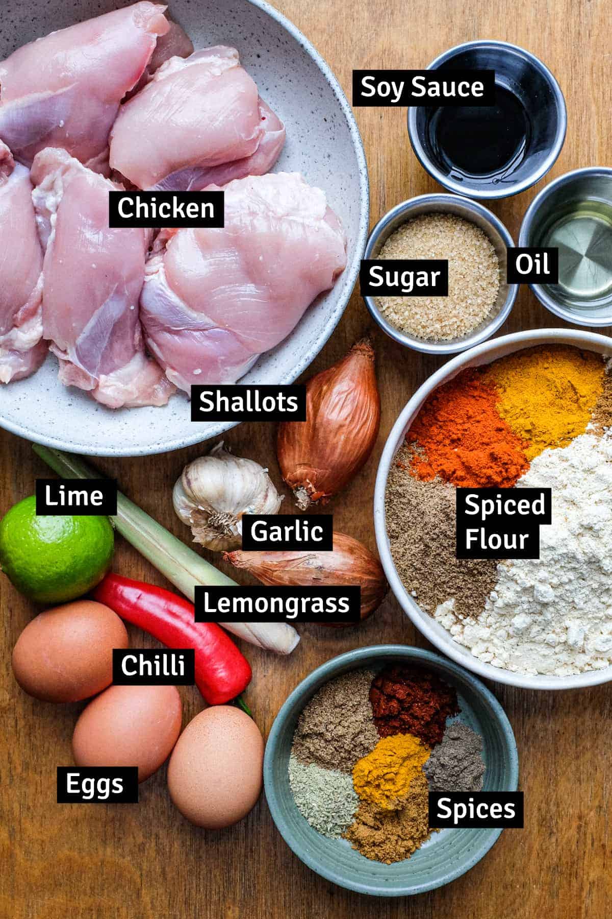 The ingredients for Malaysian fried chicken all laid out on a wooden surface.