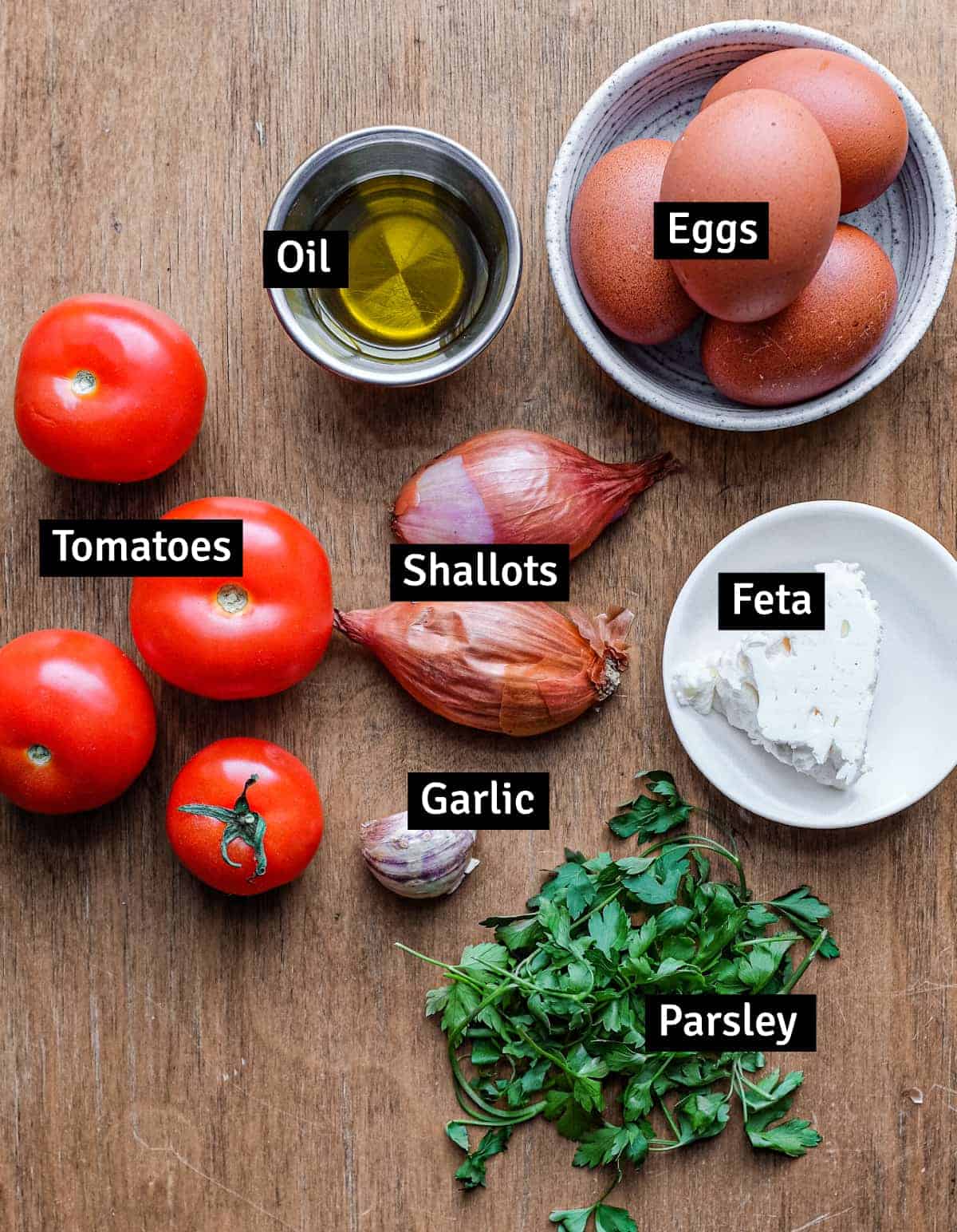 The ingredients for Greek strapatsada: eggs, tomatoes, shallots, parsley, oil, garlic and feta cheese.