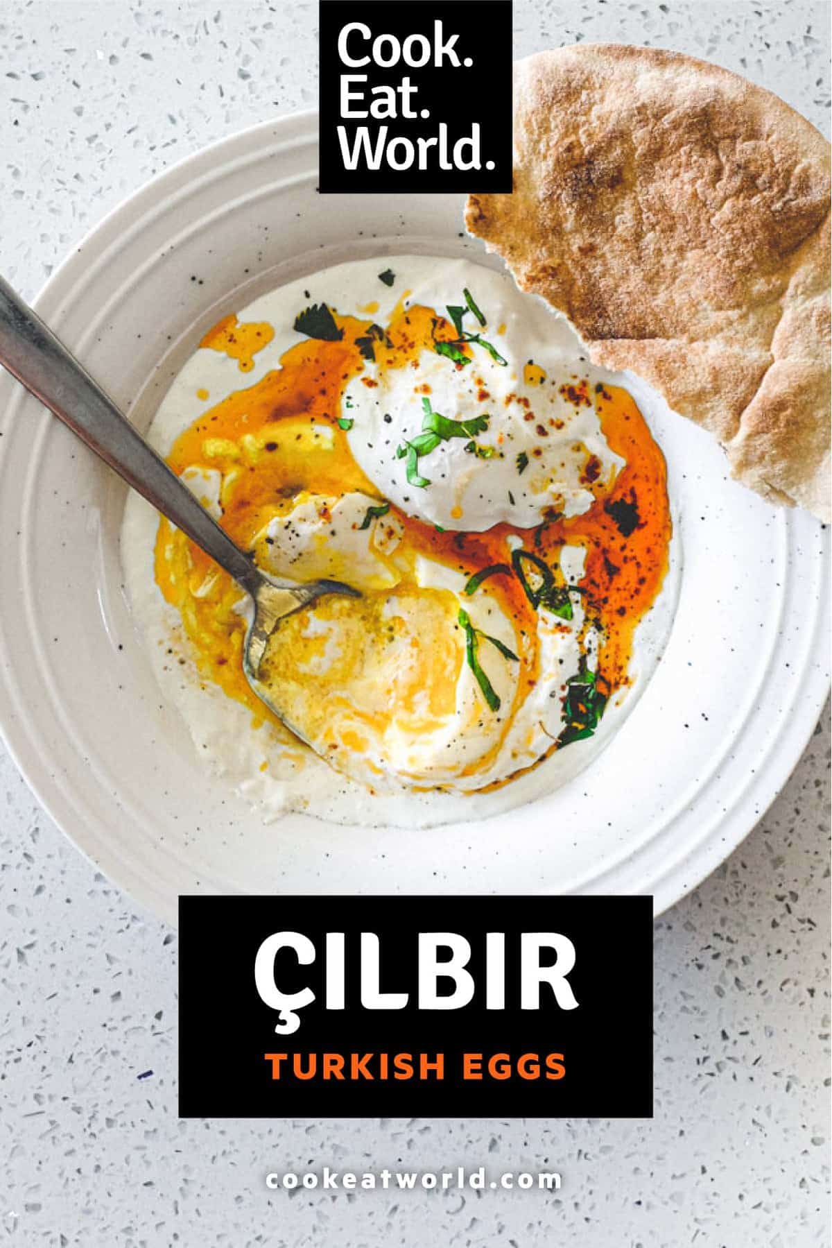 A small bowl of Turkish Cilbir (poached eggs) drizzled in orange Aleppo pepper butter with a piece of flatbread