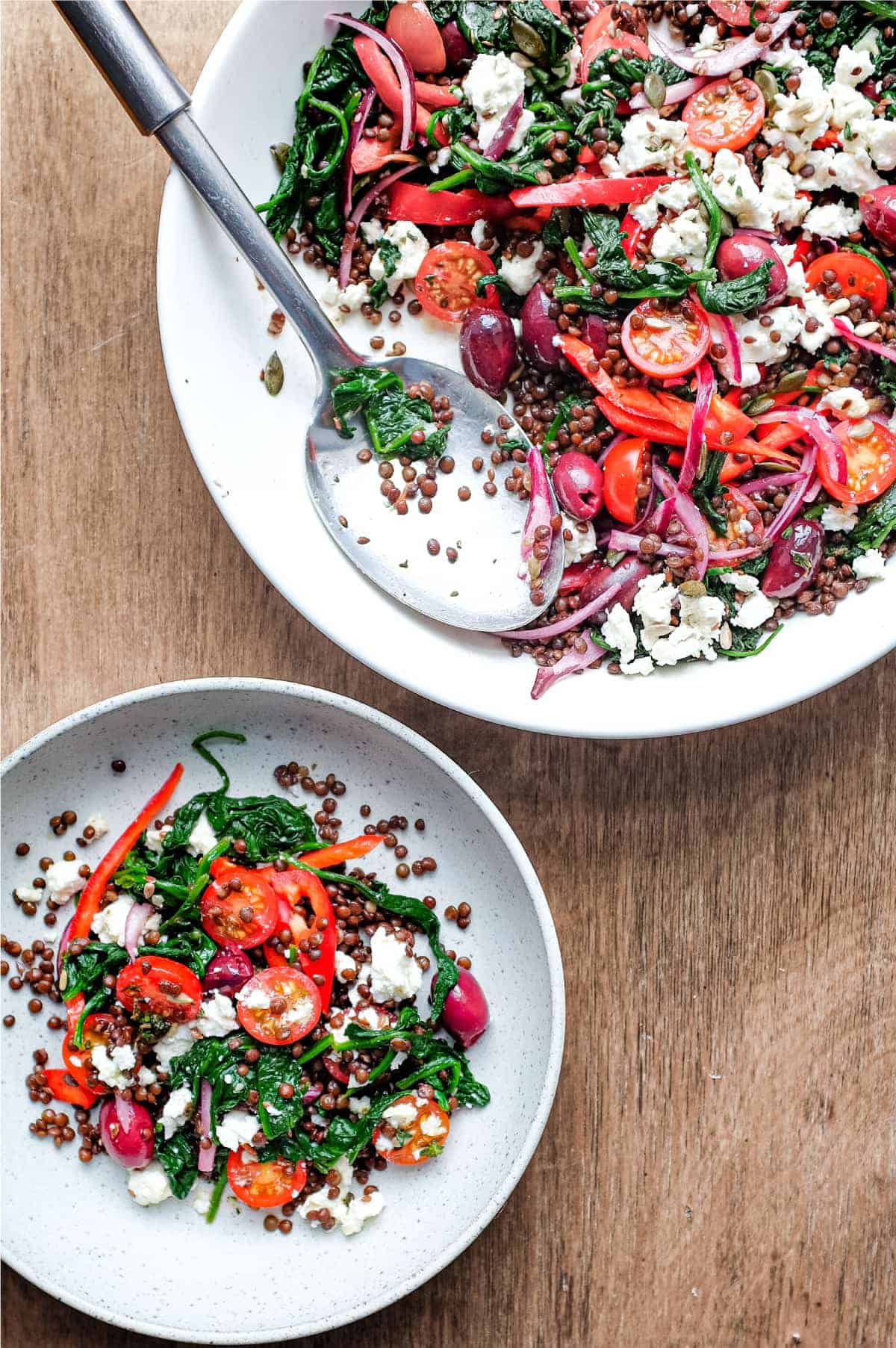 a serving bowl and smaller plate of Greek lentil salad