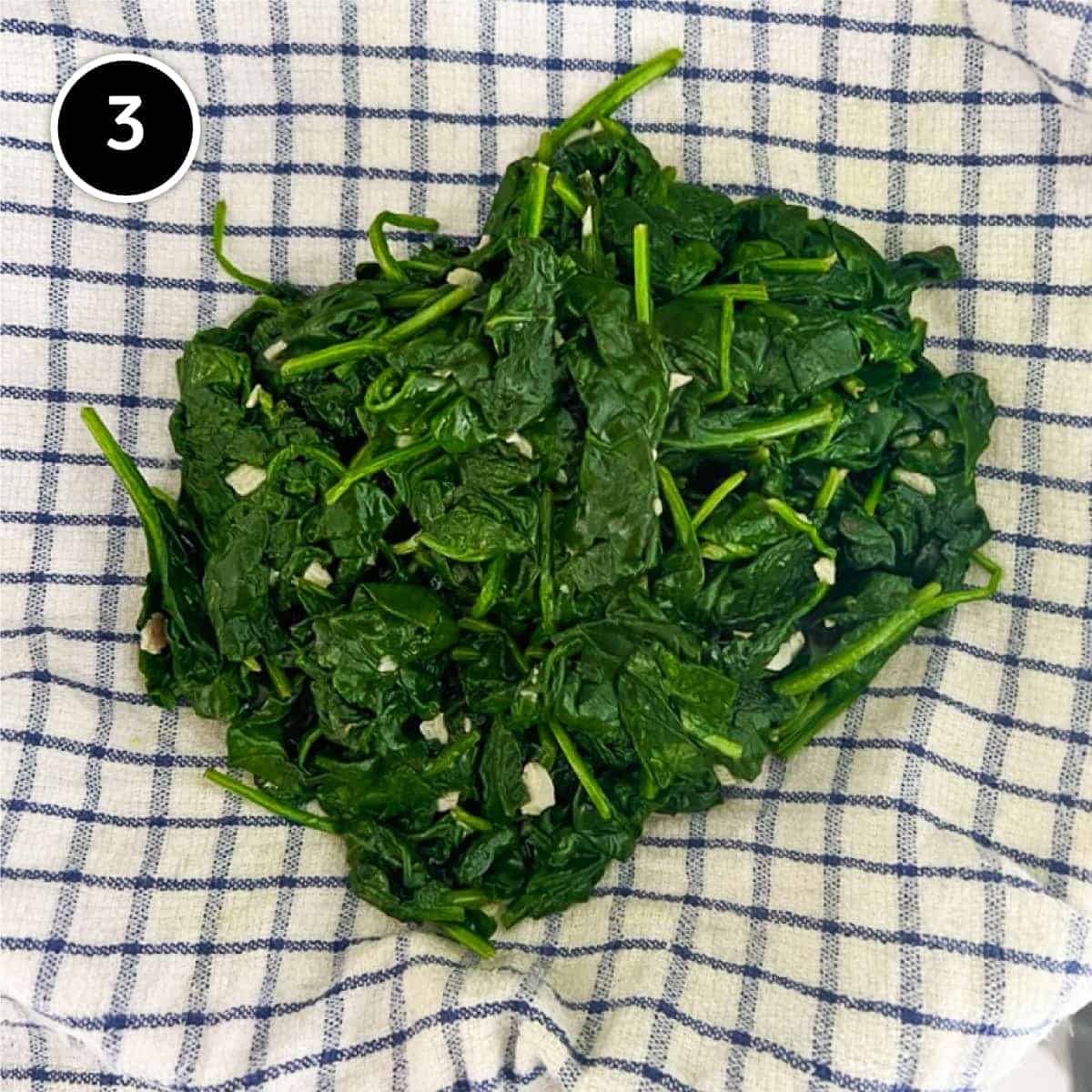Cooked spinach in a tea towel 