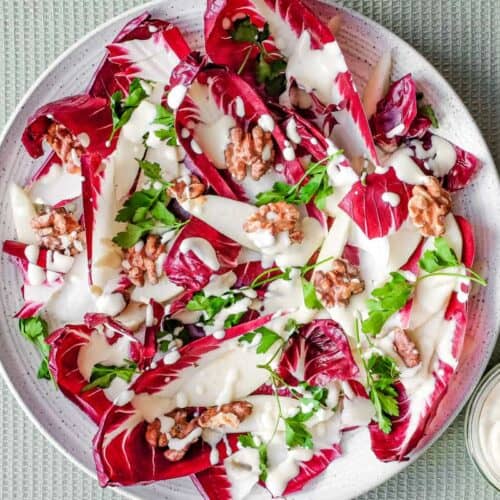 A platter of radicchio salad with pears, walnuts, parsley and a gorgonzola dressing