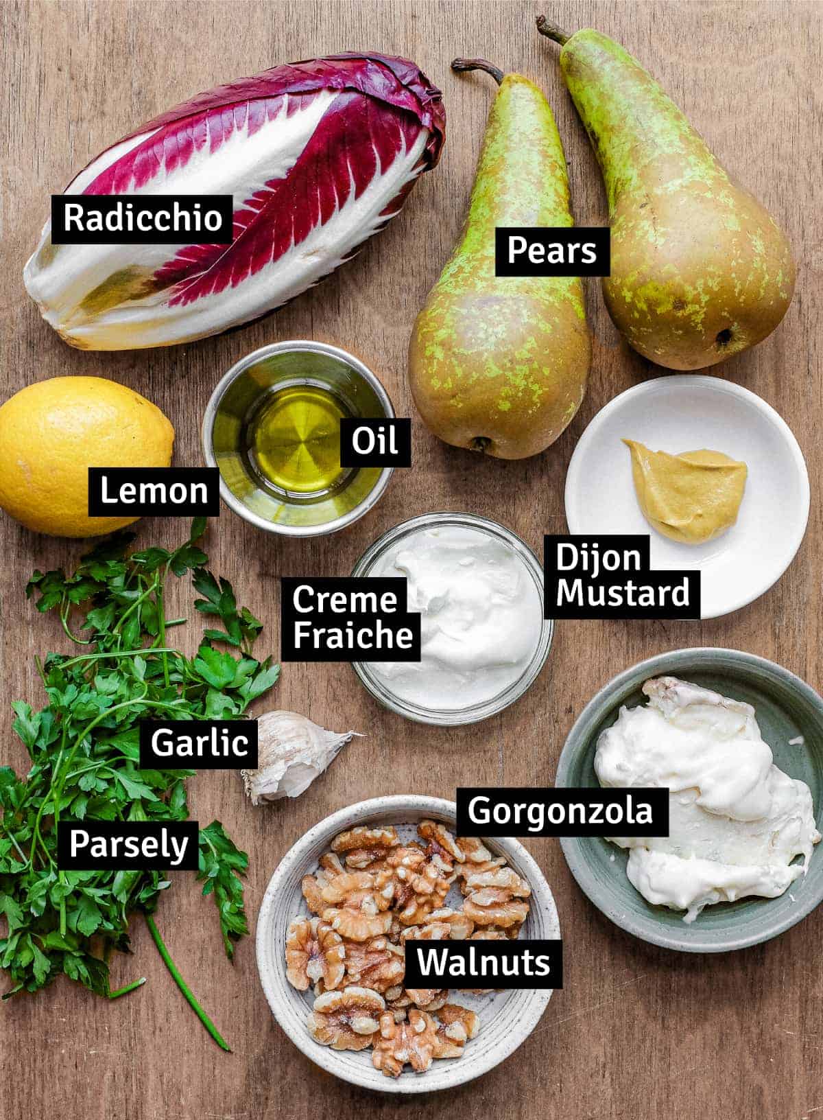 the ingredients for a radicchio, pear, and walnut salad with gorgonzola dressing: radicchio, pears, oil, lemon, gorgonzola, mustard, parsley, walnuts, garlic and creme fraiche.