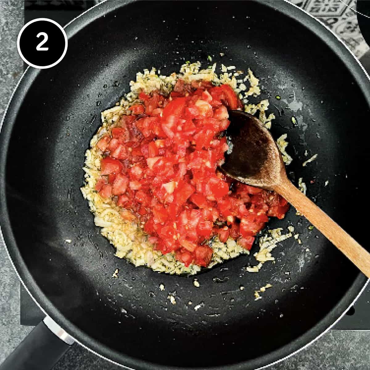 Tomatoes being added to a pan with onion and garlic