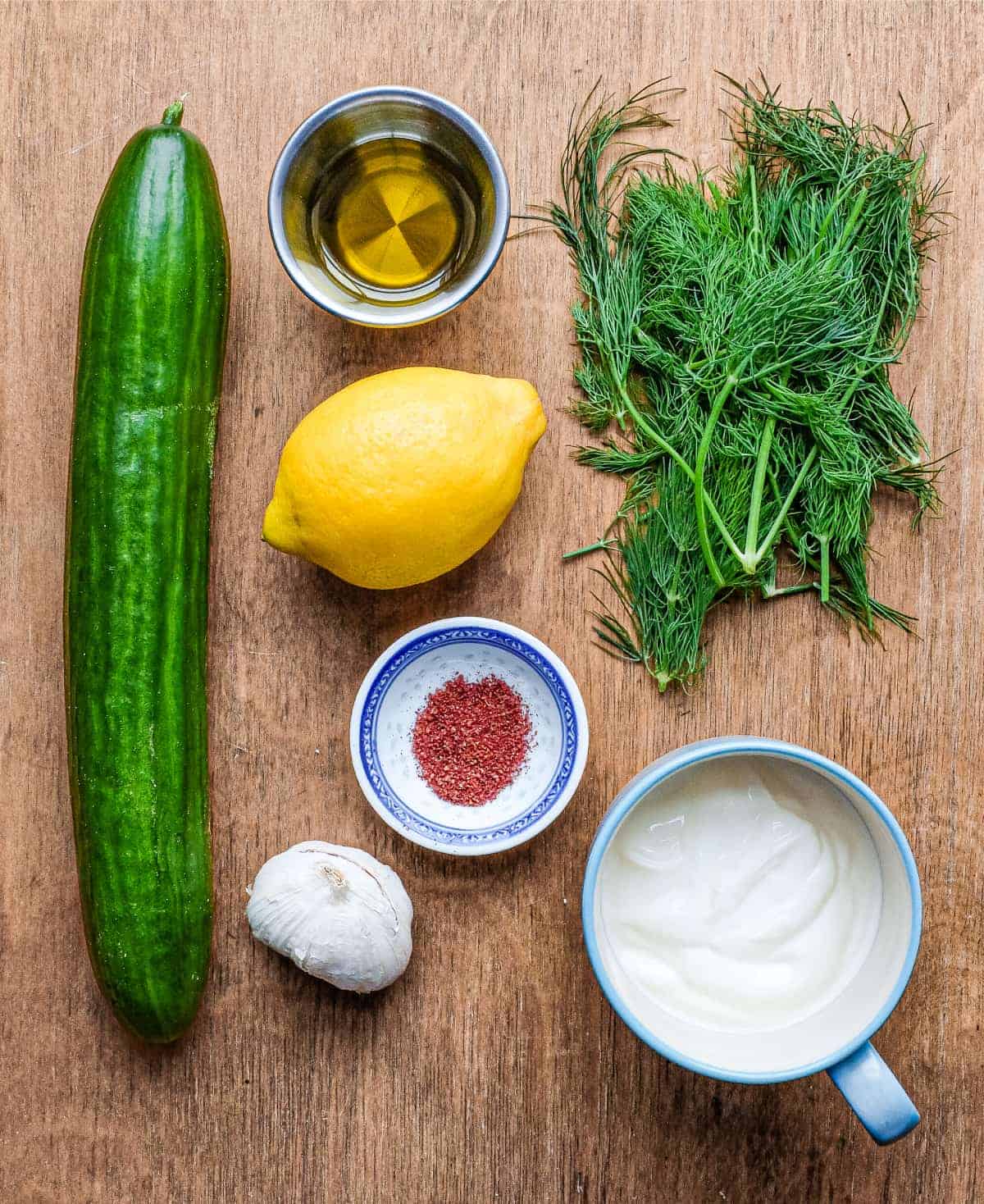 the ingredients for Turkish Cacik - a yoghurt and cucumber meze or condiment: Yoghurt, cucumber, dill, lemon, olive oil, garlic and sumac