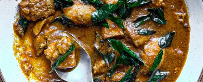 A bowl of Chicken Madras Curry scattered with fried curry leaves