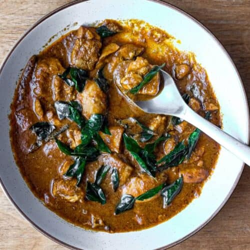 A bowl of Chicken Madras Curry scattered with fried curry leaves