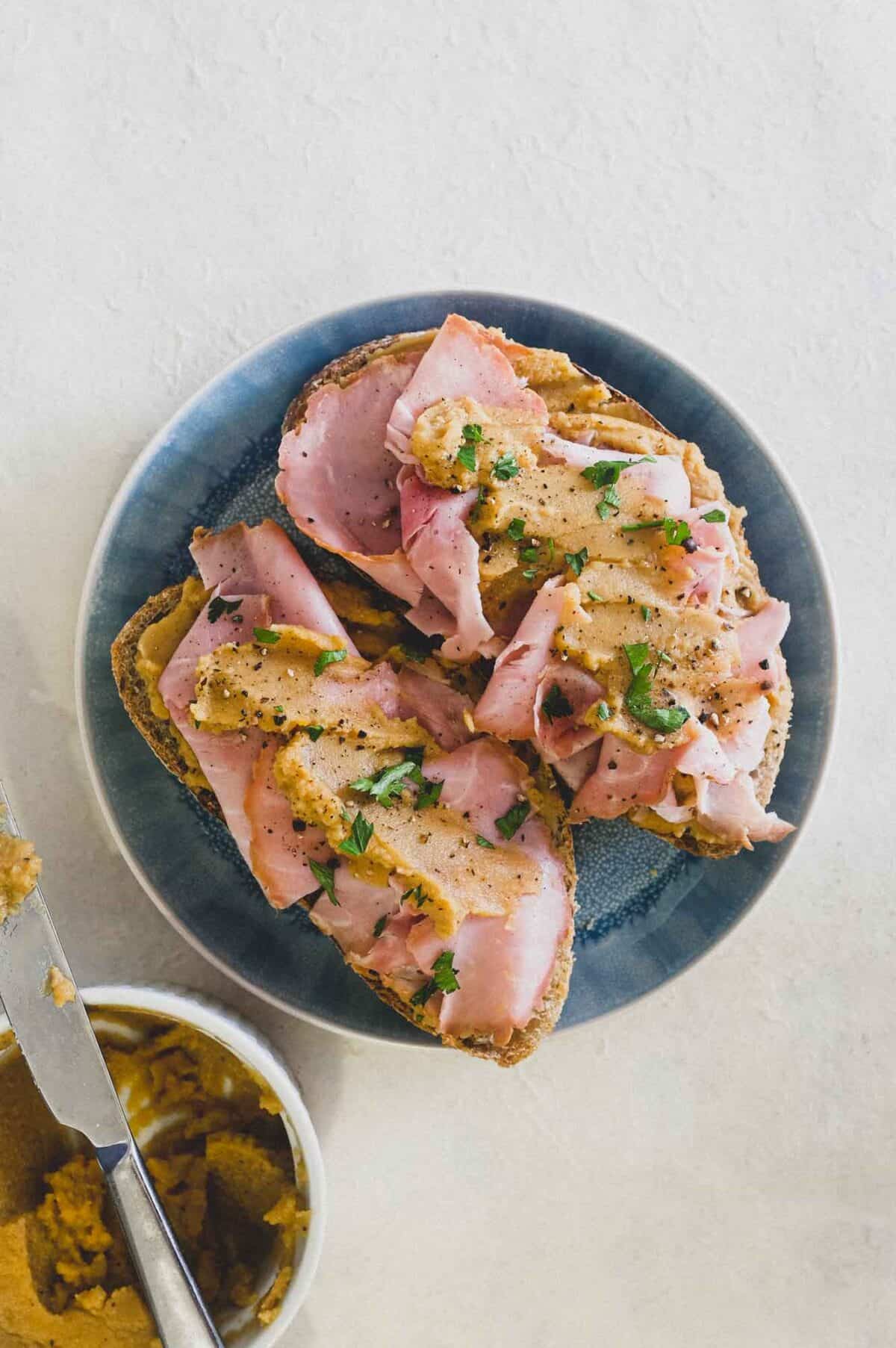 A an open sandwich with ham and pease pudding.