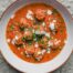 A bowl of Kofta (meatball) curry drizzled with yoghurt and g